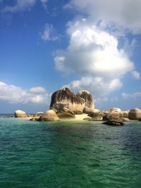 Rock formation in sea against sky