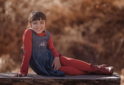 Portrait of smiling girl sitting on bench