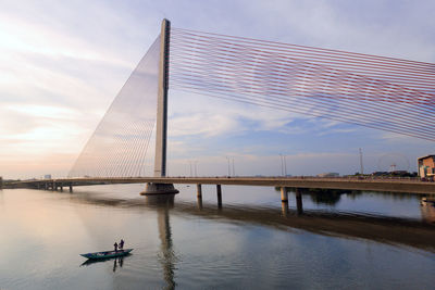 Bridge over river against sky during sunset