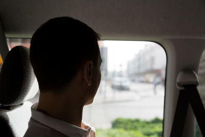 Portrait of man looking through car window