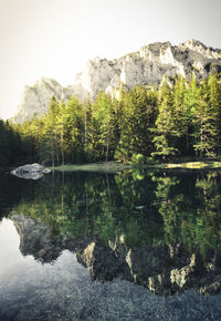 Scenic view of lake by mountain against sky