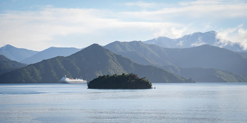 Wide view on big transport ship ferry sailing through green fjords, new zealand