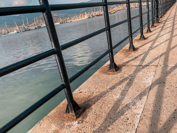 High angle view of bench on footpath by river