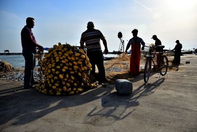 Rear view of people on motorcycle against sky