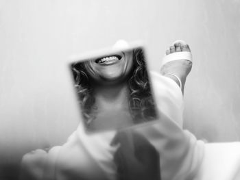 Portrait of smiling young woman against wall