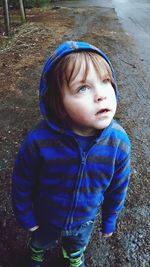 High angle view of cute boy looking away while standing on road 