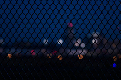 Chainlink fence against airport building at night. 