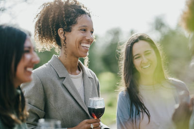 Happy multiracial female friends standing at backyard during party