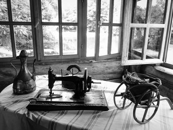 Close-up of old sewing machine on table by window