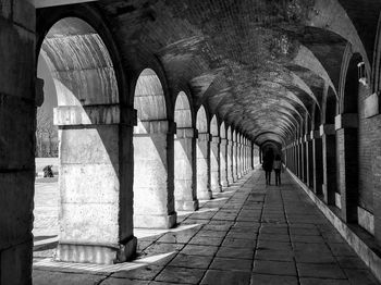 Rear view of man walking in corridor of building