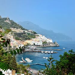 Scenic view of sea and townscape against clear sky