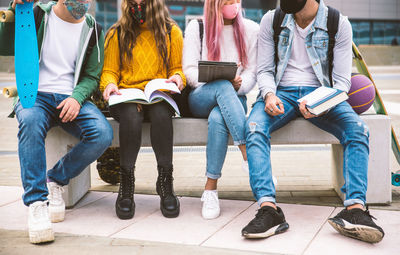 Rear view of people sitting on book