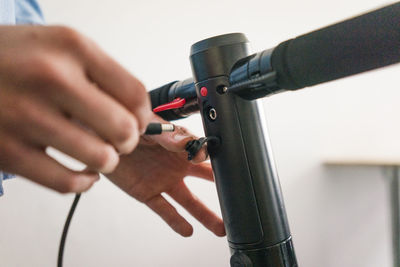 Hand puuting charging cable in e-scooter