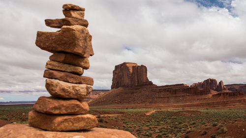 Stack of rocks on rock against sky