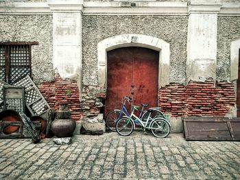 Bicycles parked on paving street against old building