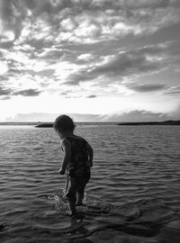 Full length of boy standing on beach against sky