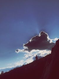 Low angle view of silhouette mountain against blue sky