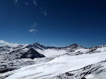 Scenic view of snowcapped mountains against blue sky