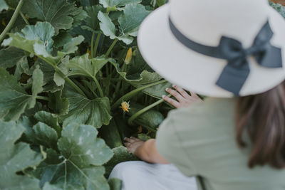 Rear view of woman holding plant