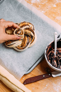 Close up of woman holding pastry on wax paper