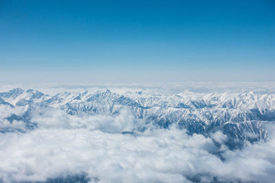 Scenic view of snowcapped mountains against blue sky