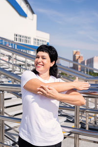 Portrait of smiling man standing against railing