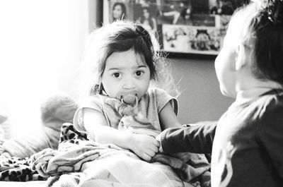 Portrait of sister playing with brother at home