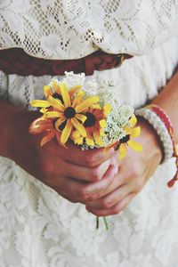 Close-up of cropped hand holding flower