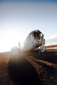 Abandoned airplane on land against sky