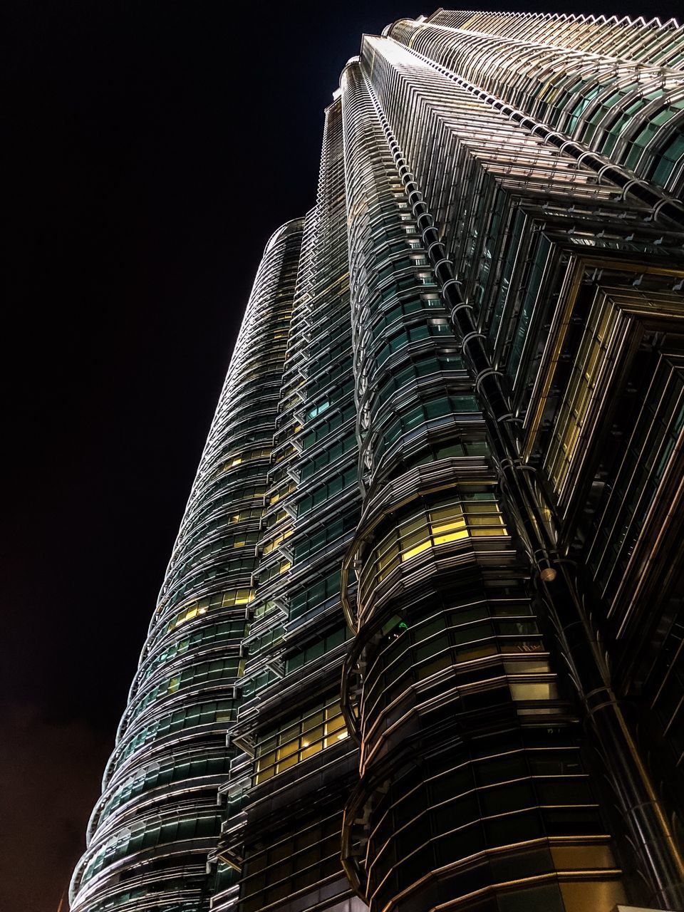 LOW ANGLE VIEW OF ILLUMINATED BUILDINGS AGAINST CLEAR SKY AT NIGHT