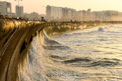 Panoramic view of sea by city against sky