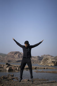 Man standing on beach against clear sky