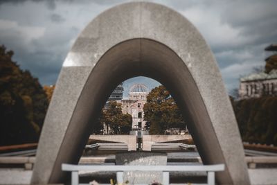 Arch bridge in city against sky