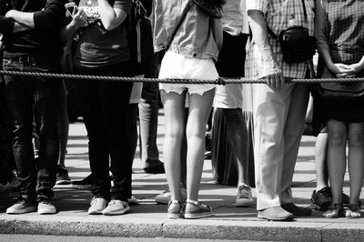 Low section of people standing on sidewalk