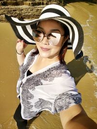 Portrait of smiling young woman standing in water