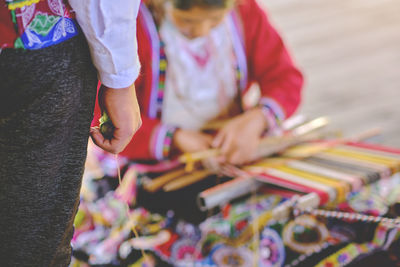 Indigenous woman showing traditional weaving technique and textile making in the andes mountain 