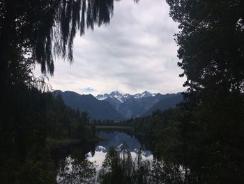 Scenic view of lake in forest against sky