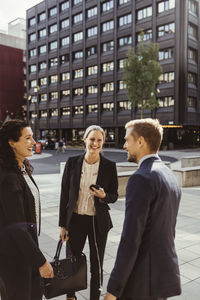 Smiling male and female entrepreneurs standing outdoors