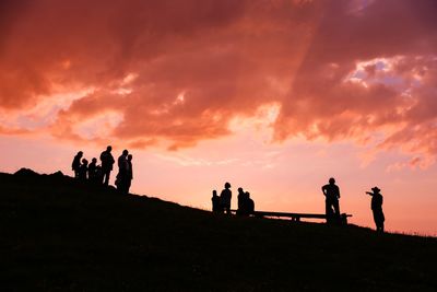 Silhouette people standing against sky during sunset