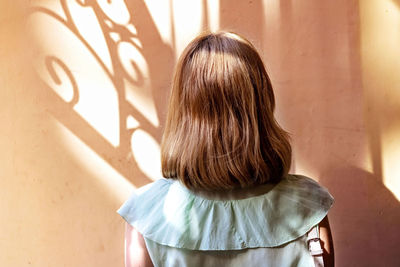 Portrait of a young woman with red hair standing back