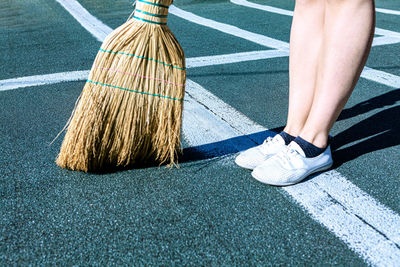 Sweeping roofing material on roofs . broom and feet view