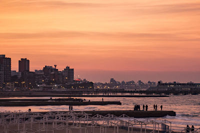 View of city at waterfront during sunset