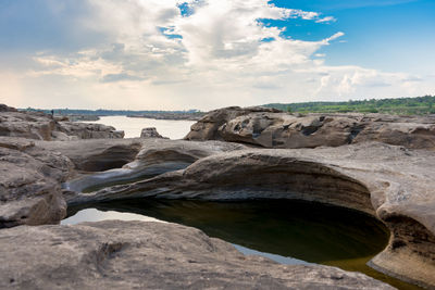 Rock formation on beach against sky