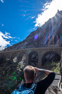 Rear view of man on bridge against sky