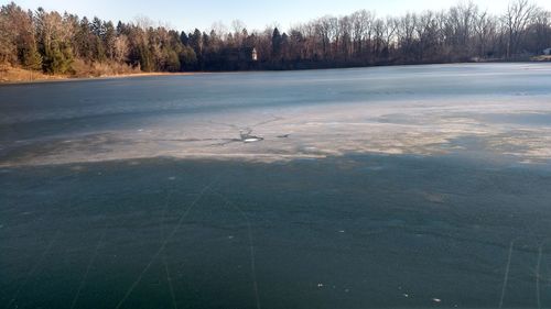 Scenic view of lake against sky during winter