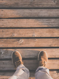 Low section of man standing on wood