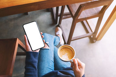 Woman holding coffee cup on table