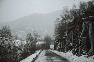 Road amidst snowcapped mountains against sky