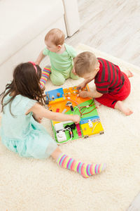 High angle view of children playing with toy on floor