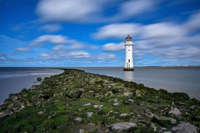 Lighthouse on sea against sky